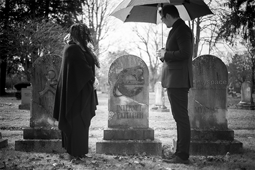 Man and women looking at gravestone